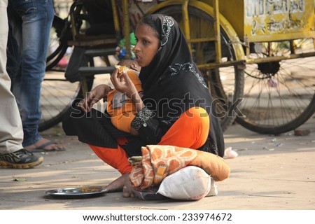 Delhi, India, November 25, 2012: Indian mother asking charity with her baby