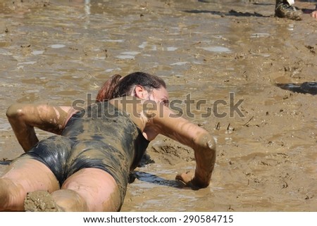 SIGNA, ITALY - MAY 9 2015: A woman lie down in the mud during the Mud Run competition near Florence on May 2015