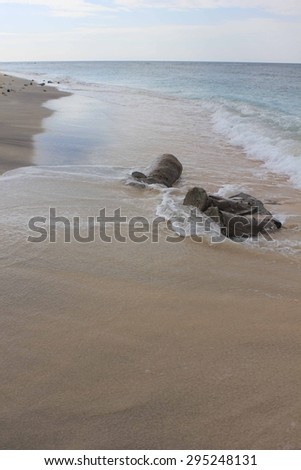GILI ISLANDS, INDONESIA - JULY 8 2012: Tropical Indonesian Gili Islands beach water\'s edge in a dull day