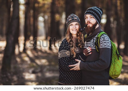 Outdoor happy couple. The bearded guy with tobacco pipe