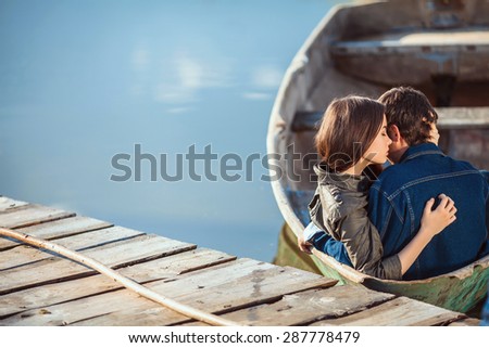 Happy romantic couple rowing a small boat on lake