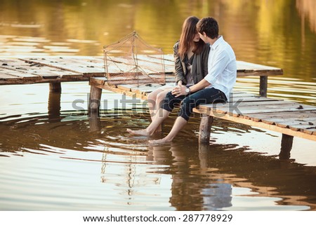 Couple on the wooden jetty at a lake