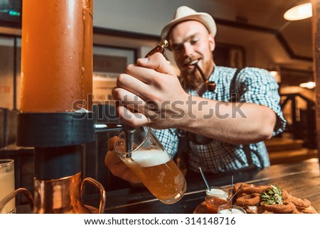 close-up of barman hand at beer tap pouring a draught lager beer