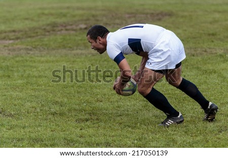ZAGREB, CROATIA - SEPTEMBER 13, 2014: Rugby match Rugby Club Zagreb in white jersey and Rugby Club Sinj in black jersey. Unidentified player run with ball.