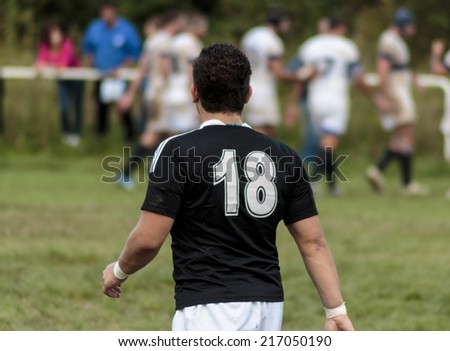 ZAGREB, CROATIA - SEPTEMBER 13, 2014: Rugby match Rugby Club Zagreb in white jersey and Rugby Club Sinj in black jersey. Unidentified player walking on field