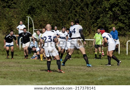 ZAGREB, CROATIA - SEPTEMBER 13, 2014: Rugby match Rugby Club Zagreb in white jersey and Rugby Club Sinj in black jersey. Unidentified player run with ball.
