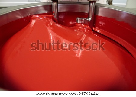 ZAGREB, CROATIA - SEPTEMBER 16, 2014: Cauldron for mixing colors in printing house. Red color in cauldron is Pantone 185 very common as fifth color in printing press