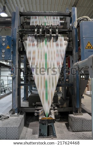ZAGREB, CROATIA - SEPTEMBER 16, 2014: View of rotation Koenig Bauer machine in Printing house. Printing machine bends paper in full speed