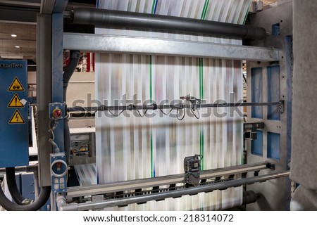 ZAGREB, CROATIA - SEPTEMBER 16, 2014: View of rotation Koenig Bauer machine in Printing house. Printing machine bends paper in full speed, paper is going through serious of rollers