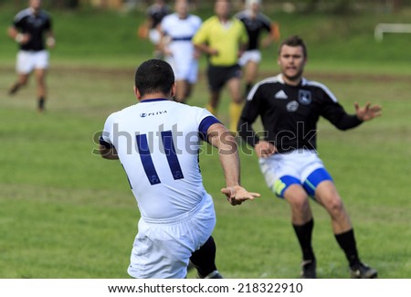 ZAGREB, CROATIA - SEPTEMBER 13, 2014: Rugby match Rugby Club Zagreb in white jersey and Rugby Club Sinj in black jersey. Unidentified player shoot\'s the ball.