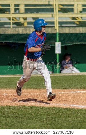 ZAGREB. CROATIA - OCTOBER 12, 2014: Baseball match Baseball Club Zagreb in blue jersey and Baseball Club Olimpija in dark blue jersey. Unidentified baseball player running with both feet in the air