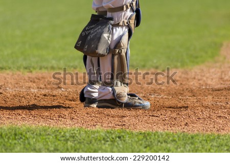 ZAGREB, CROATIA - OCTOBER 11, 2014: Baseball match Baseball Club Zagreb in white jersey and Baseball Club Medvednica in red jersey. Unidentified baseball catcher legs with knee s\'port