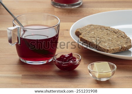 Strawberry tea, strawberry jam, butter and rye bread for breakfast