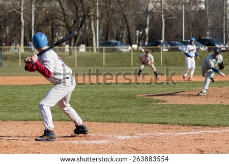 ZAGREB, CROATIA - MARCH 21, 2015: Baseball match Baseball Club Zagreb in blue jersey and Baseball Club Olimpija in gray jersey. Pitcher throwing the ball and batter is ready to hit it