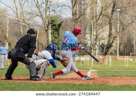 ZAGREB, CROATIA - MARCH 28, 2015: Baseball match Baseball Club Zagreb in white jersey and Baseball Club Nada in blue jersey. Baseball batter, catcher and plate umpire. View from back