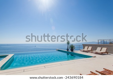 Luxury swimming pool and blue water at the resort with beautiful sea view