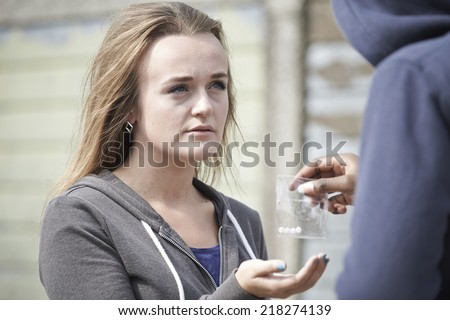 Teenage Girl Buying Drugs On The Street From Dealer