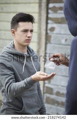 Teenage Boy Buying Drugs On The Street From Dealer