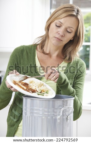 Woman Scraping Food Leftovers Into Garbage Bin