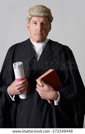 Portrait Of Male Lawyer Holding Brief And Book