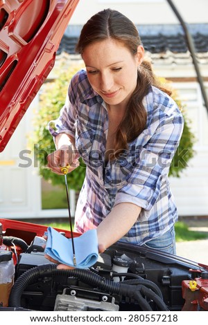 Woman Checking Car Engine Oil Level Under Hood With Dipstick