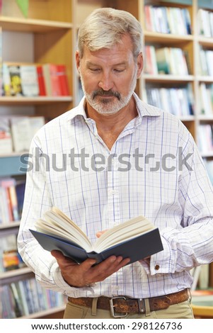 Male Customer Reading Book In Bookstore