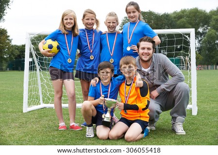 Victorious School Soccer Team With Medals And Trophy