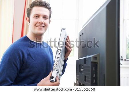Portrait Of Engineer Installing Digital TV Equipment