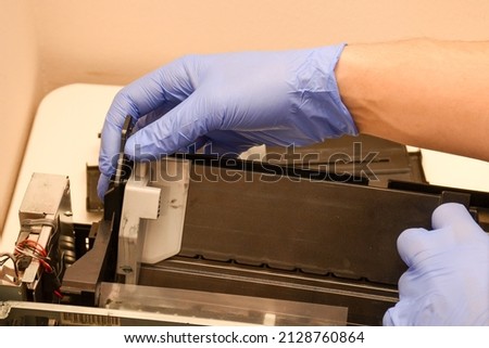 The master repairs the paper feed tray on an inkjet printer. Close-up photo o work Foto stock © 