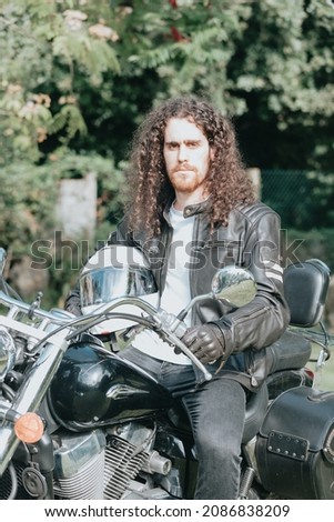 Similar – Image, Stock Photo Young long hair motorbike guy smiling to camera while checking his phone while sitting on his old school motorbike during a break from the road route. Liberty life, young man heavy metal, white tshirt