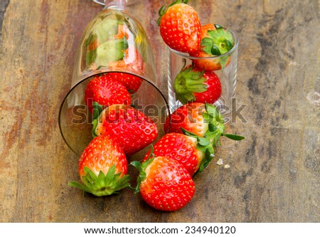 close up of fresh strawberries on the table and inside grass on wooden background