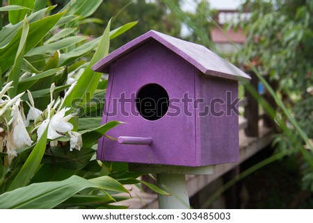 Purple Wooden bird houses beside the river.