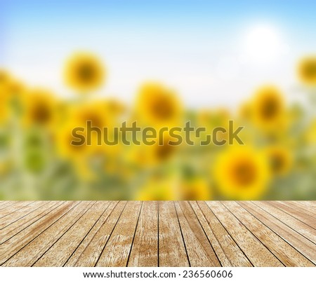 Backdrop Sunflower in a field (blurred) and wood slabs arranged in perspective texture background.