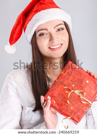 Christmas Santa hat. woman portrait hold christmas gift. Smiling happy girl.christmas, x-mas, winter, happiness concept - smiling woman in sweater and hat with gift box