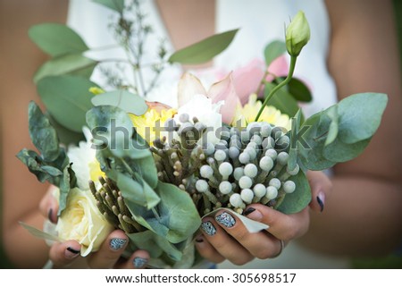 bride holding wedding bouquet of eucalyptus and roses