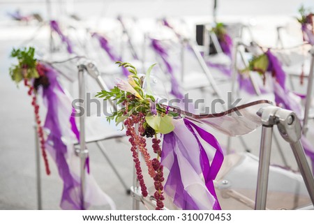 flowers on the chairs for a wedding ceremony