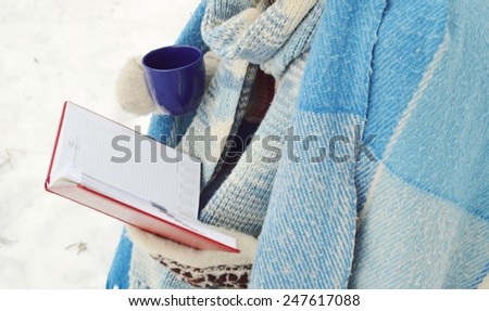girl wrapped a blanket reading a book. winter concept