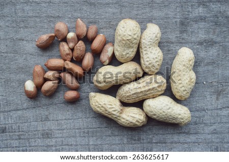 peanuts in shell and shelled peanuts, almonds on a wooden table