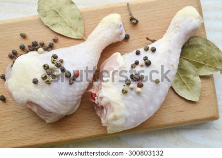 raw chicken thigh with herbs on a wooden Board