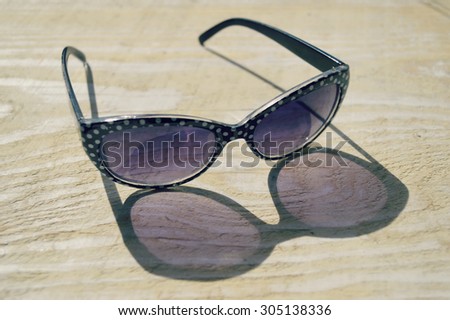 fashionable sunglasses on a wooden table closeup