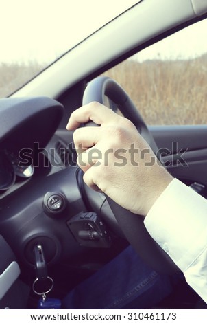 Hand holding car key for starting the car.Male hand with car key on car background
