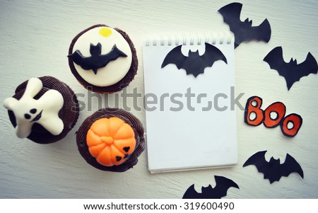 Happy Halloween Cupcakes.Halloween cookies.recipe book.Preparation for sweet cupcakes with sweet cream