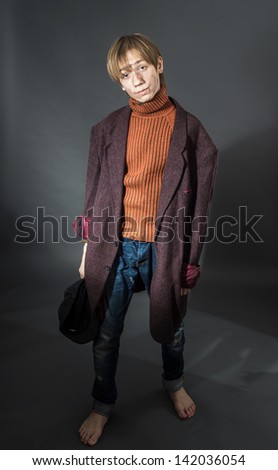 Young actor showing beggar. Old coat and dirty face.