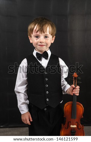 Freckled red-hair boy playing violin. Young musician.