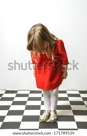 Little girl on checkered floor like Alice in Wonderland