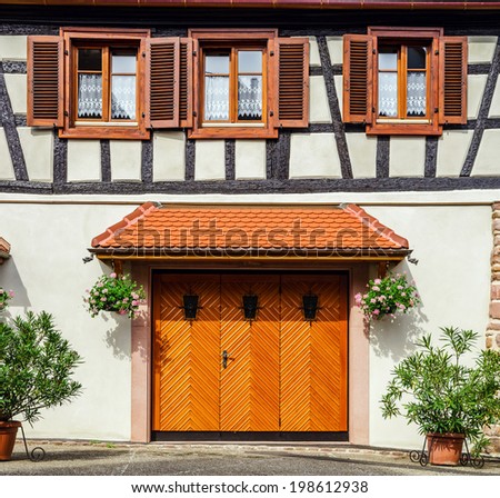 Renovated wooden garage doors in old house, Alsace, France
