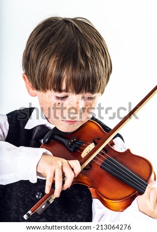 Red-haired preschooler boy with violin, music education