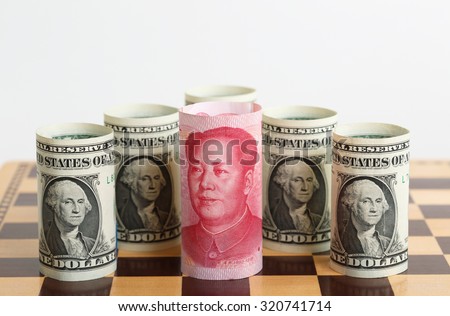 Currency War. Photos Shows a Chinese Currency Note Surrounded by US Currency Notes on a Chess Board