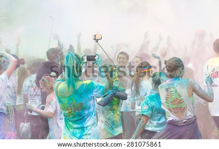 STOCKHOLM - MAY 23, 2015: The participator in the Color Run waving their arms in the air and taking photos in the public event The Color Run, May 23, 2015 in Stockholm, Sweden