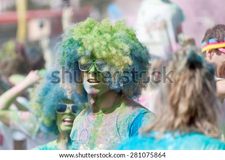 STOCKHOLM - MAY 23, 2015: Two participant wearing large hippie style wigs and covered with blue and green color powder in the public event The Color Run, May 23, 2015 in Stockholm, Sweden
